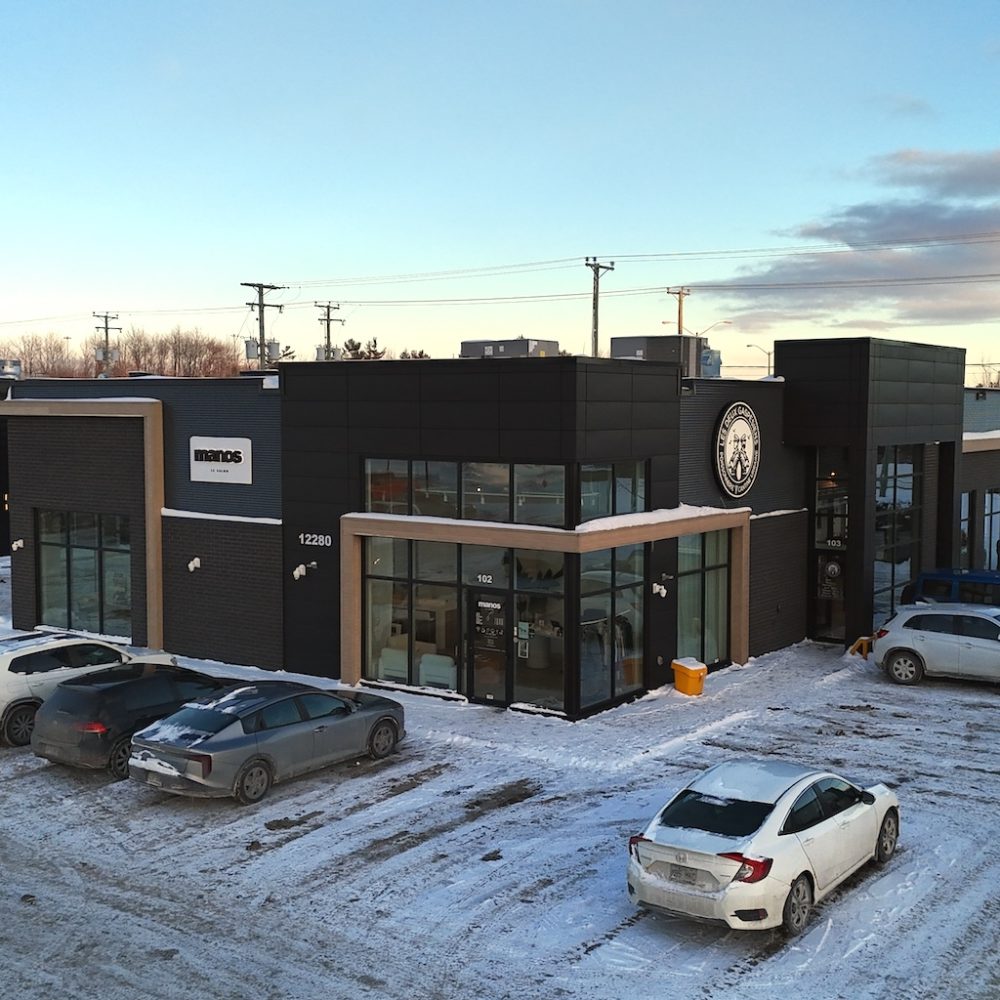 Bâtiment commercial noir et bois à l’architecture moderne à Mirabel, développé par Investissement Ray Junior